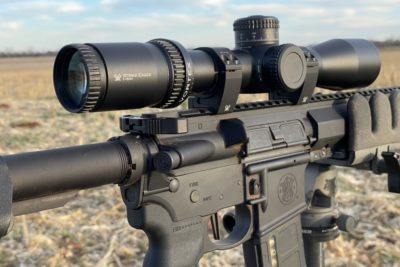 The all-new Vortex Strike Eagle 3-18x44 FFP Riflescope setup on a tripod overlooking a corn field at sunset