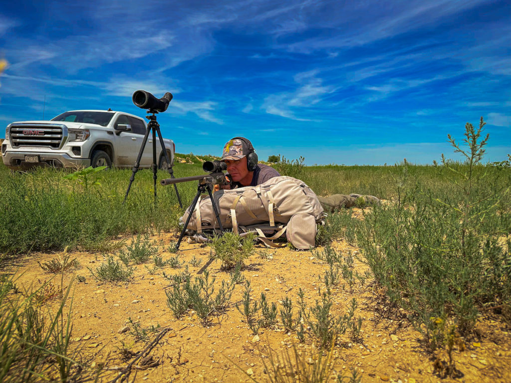 Shooter in vibrant green grass aiming the Browning X-Bolt Speed LR 7mm PRC