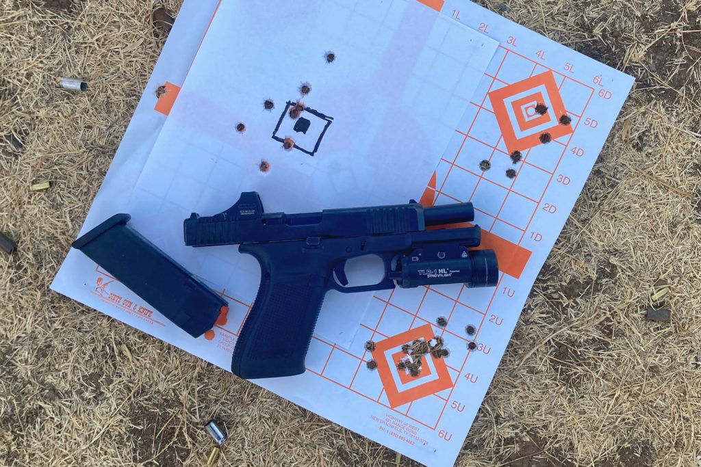 G20 Gen5 pistol with magazine against used target on dried grass